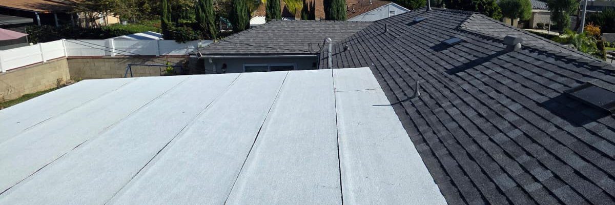 White low-slope roof section beside a dark shingle roof section